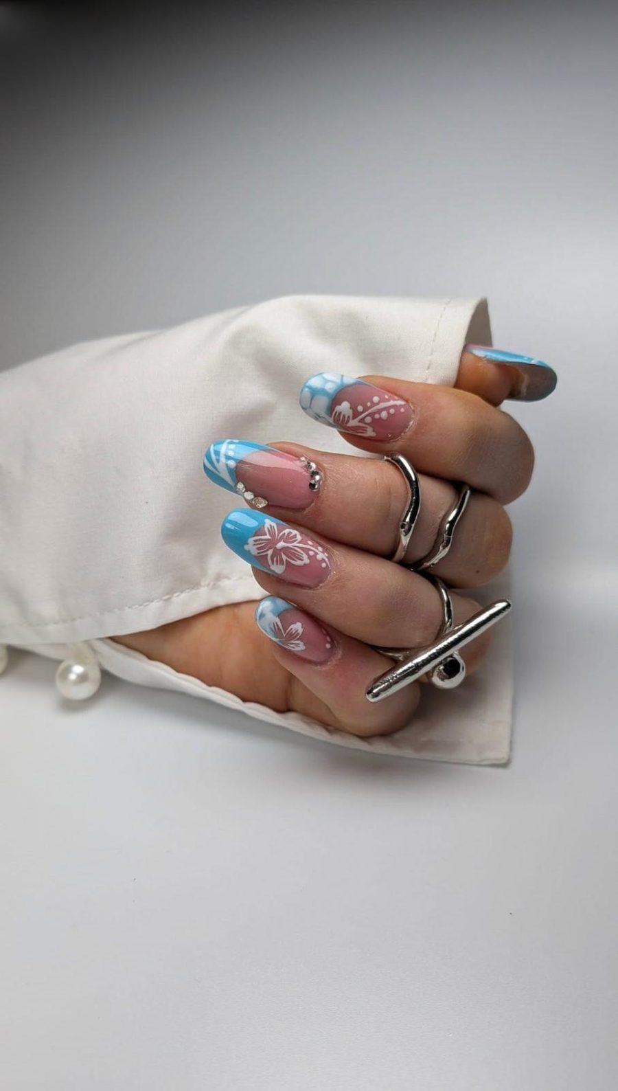 Nagelmodellage: blaues French mit weißen Hibiskusblüten