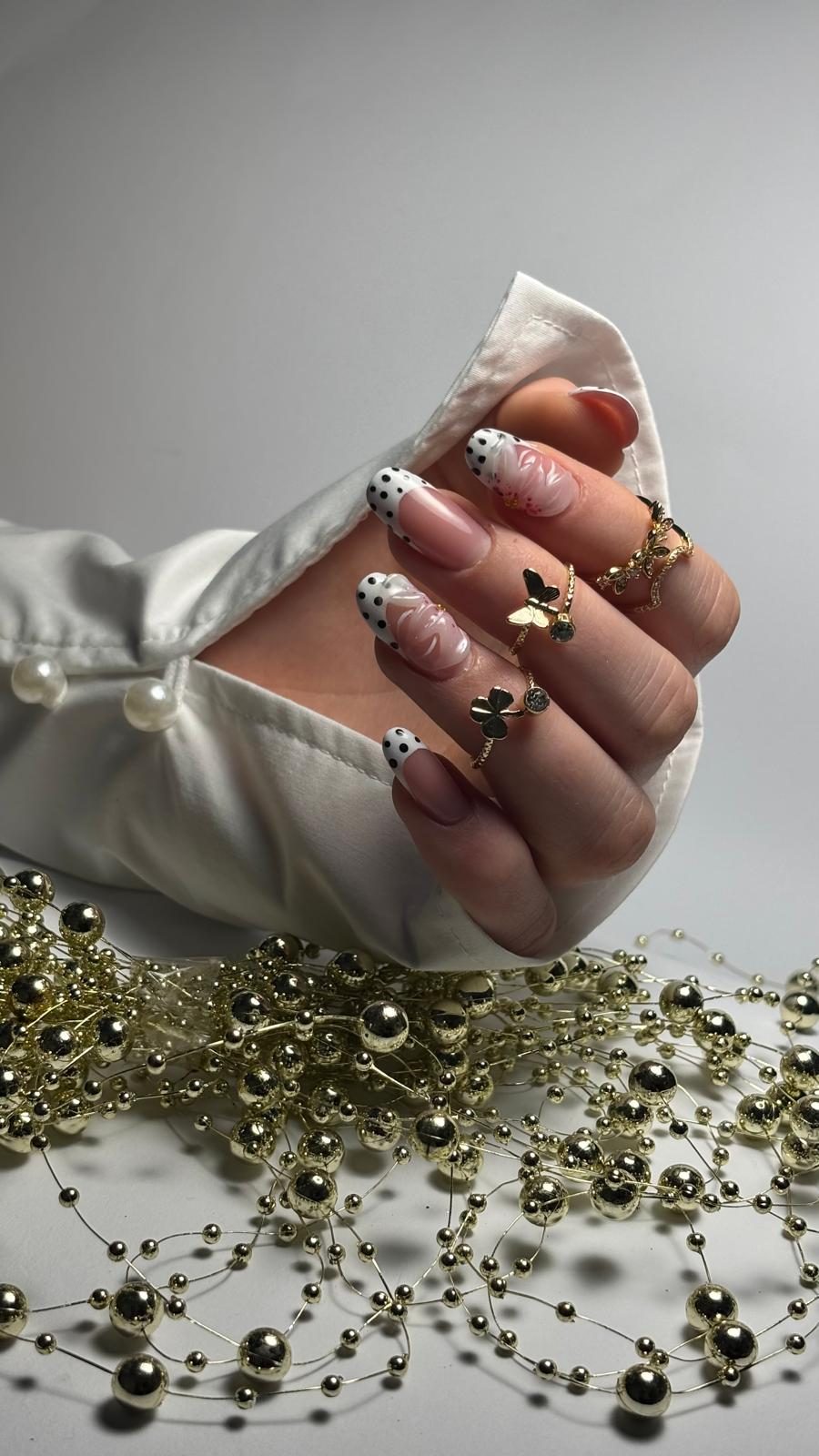 Nagelmodellage: weißes French mit Punkten und Blüte